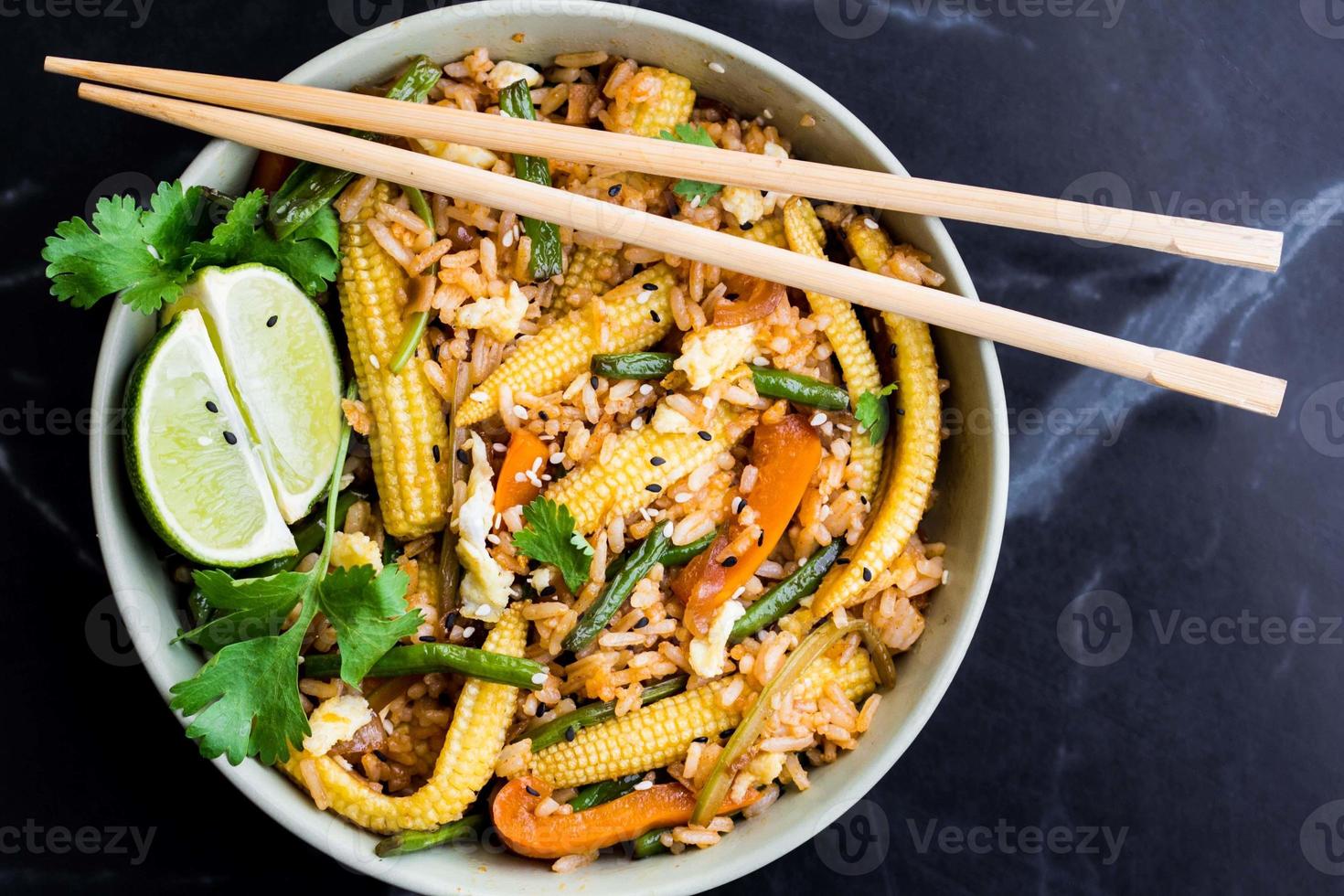 asiatiska stekt ris med ägg, grönsaker, mini majs, gröna bönor foto