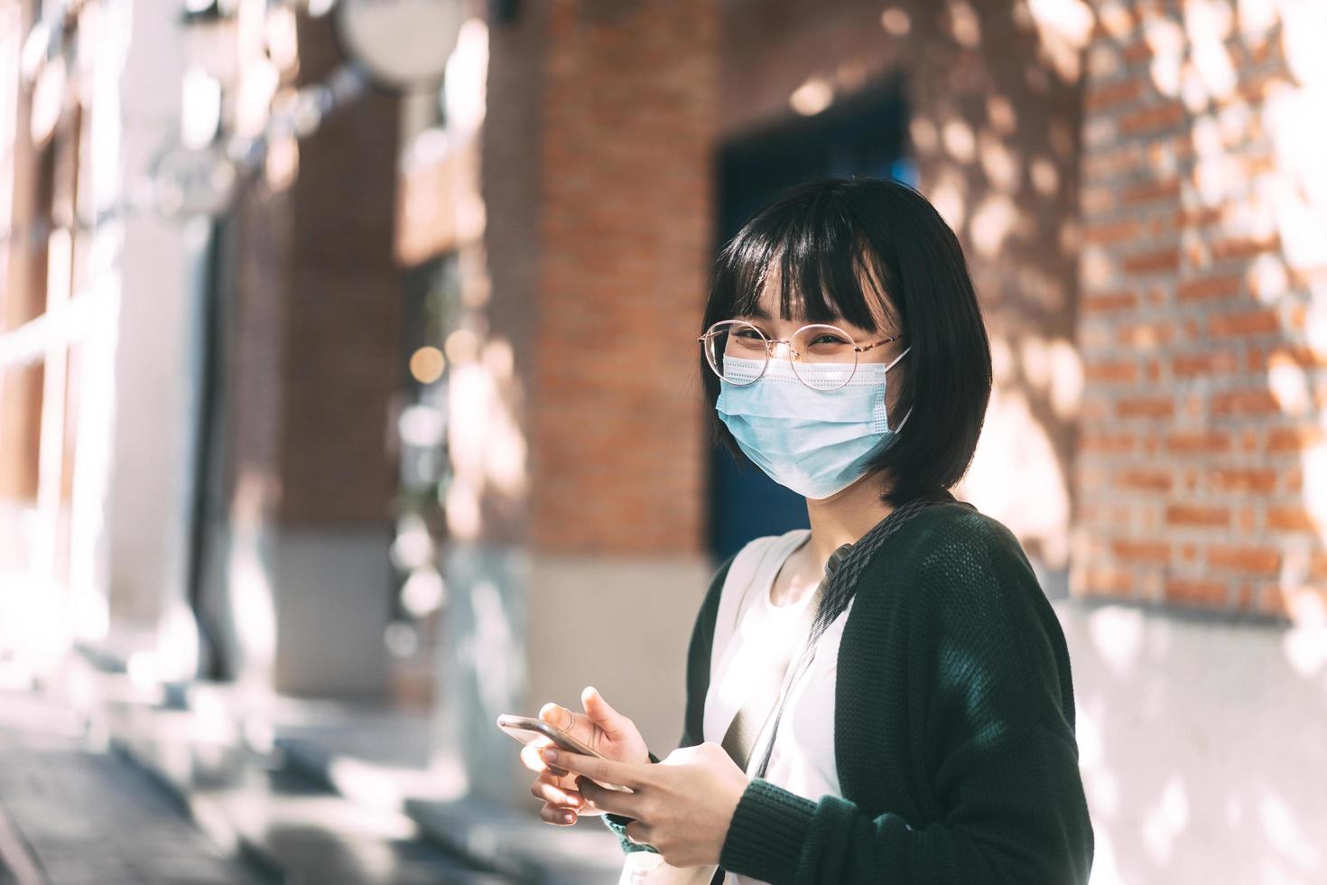 unga vuxna asiatiska glasögon kvinna bär ansiktsmask för att skydda virus corona eller covid19. foto