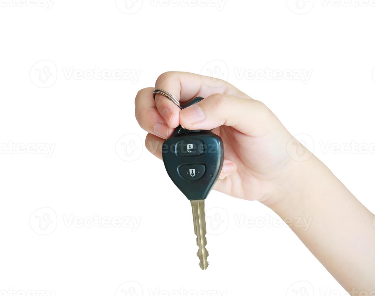 hand som håller bilnyckeln isolerad på vit bakgrund foto