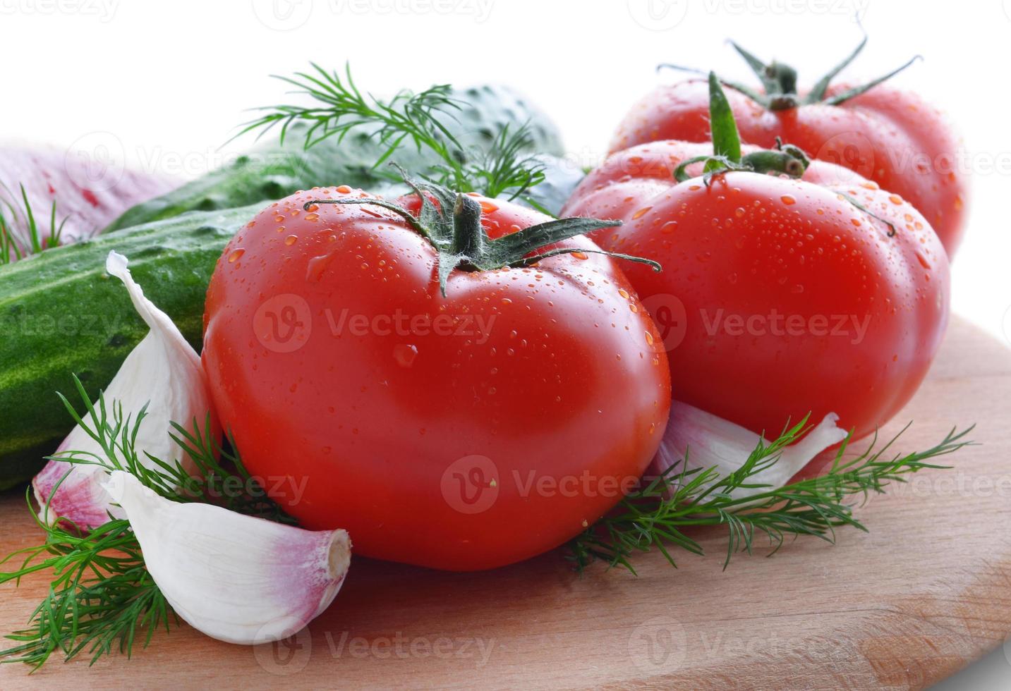 färska grönsaker: tomater, gurkor, vitlök och peppar foto