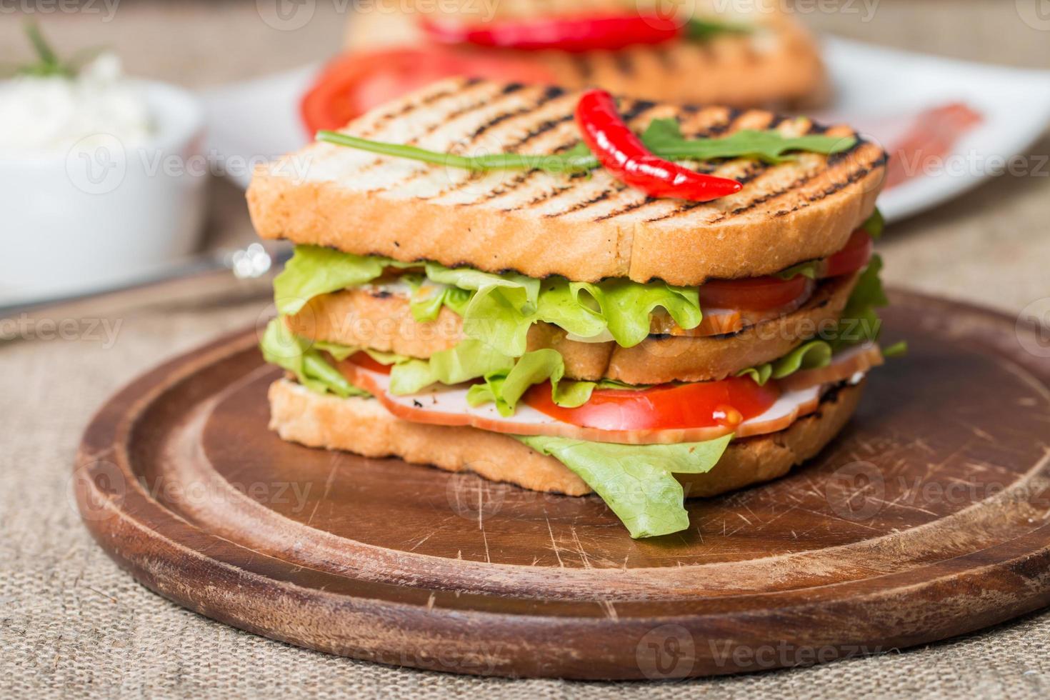 klassisk klubbsmörgås med bacon och grönsaker foto