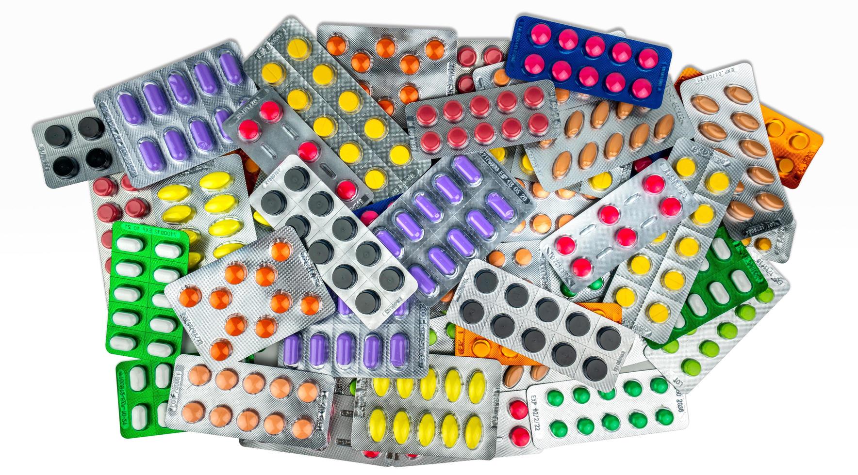 många av tablett piller isolerad på vit bakgrund. gula, lila, svarta, orange, rosa, gröna tabletter i blisterförpackning. smärtstillande medicin. läkemedel mot migrän. läkemedelsindustri. foto