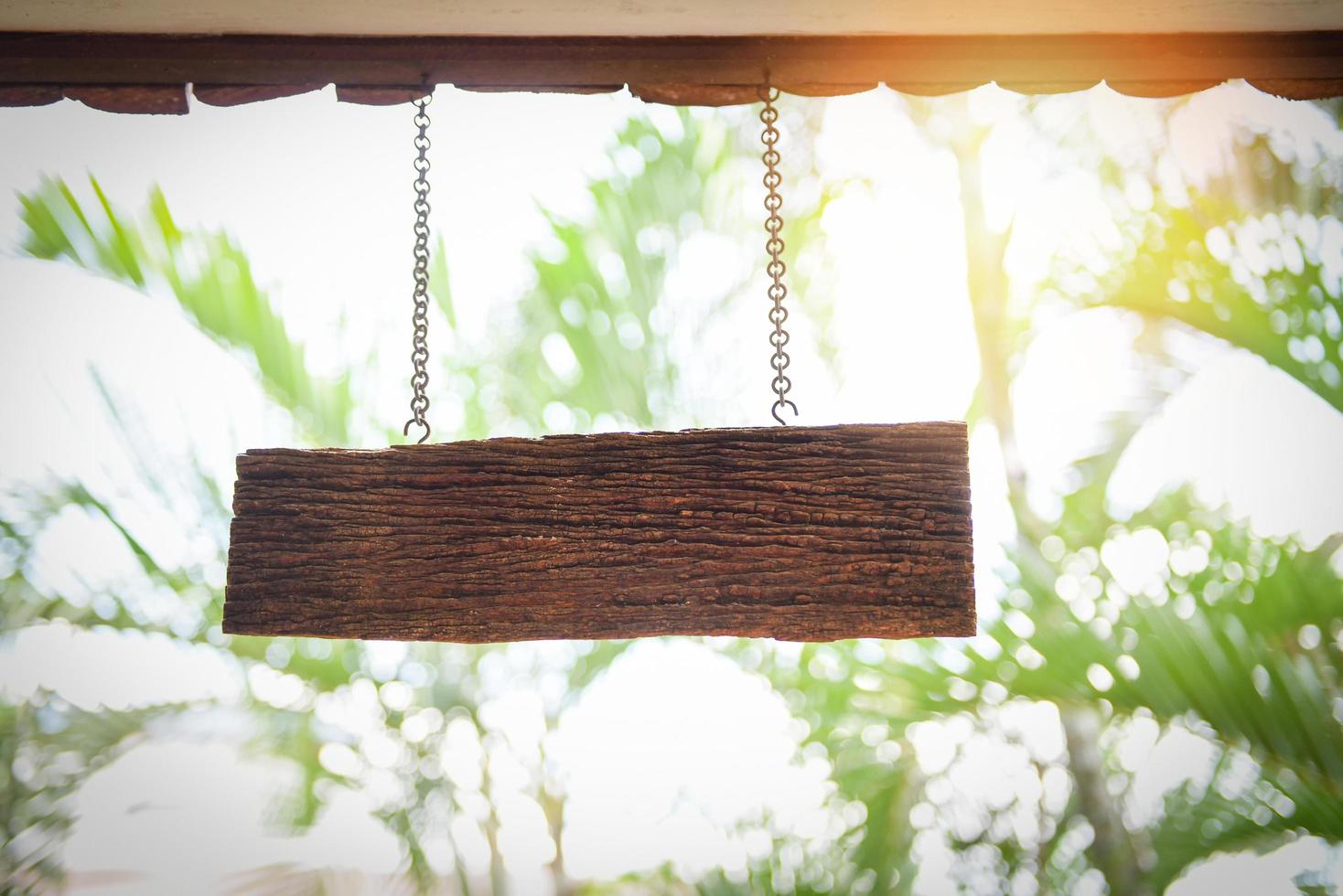 träskylt som hänger från taket - rustik skylt av ljus trä på åldrad trävägg foto