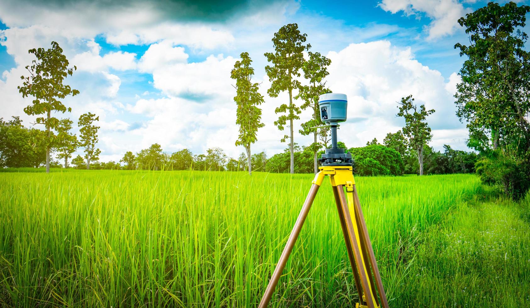 GPS lantmäteriutrustning på blå himmel och vita moln bakgrund. gps-, gis- och gnss-utrustning. lantmäteri för karta. teknik för att markera mark till satellitkarta på jorden. smart gnss gps-undersökning. foto