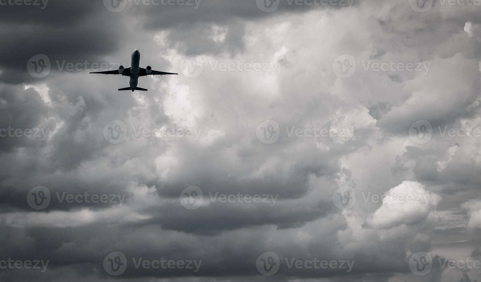 flygplan som flyger på mörk himmel och vita moln. kommersiellt flygbolag med drömdestinationer koncept. flyg affärskris koncept. misslyckad resa semesterflyg. flygtransporter. sorglig resa. foto