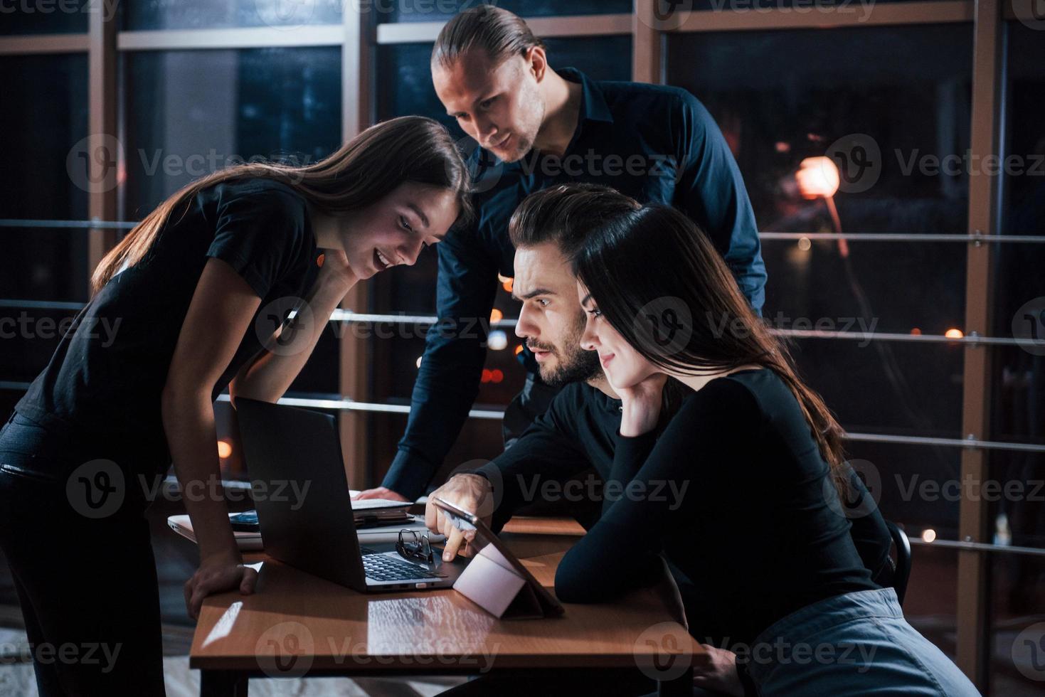 väl utfört jobb. ett team av unga affärsmän arbetar med sitt projekt på natten på kontoret foto