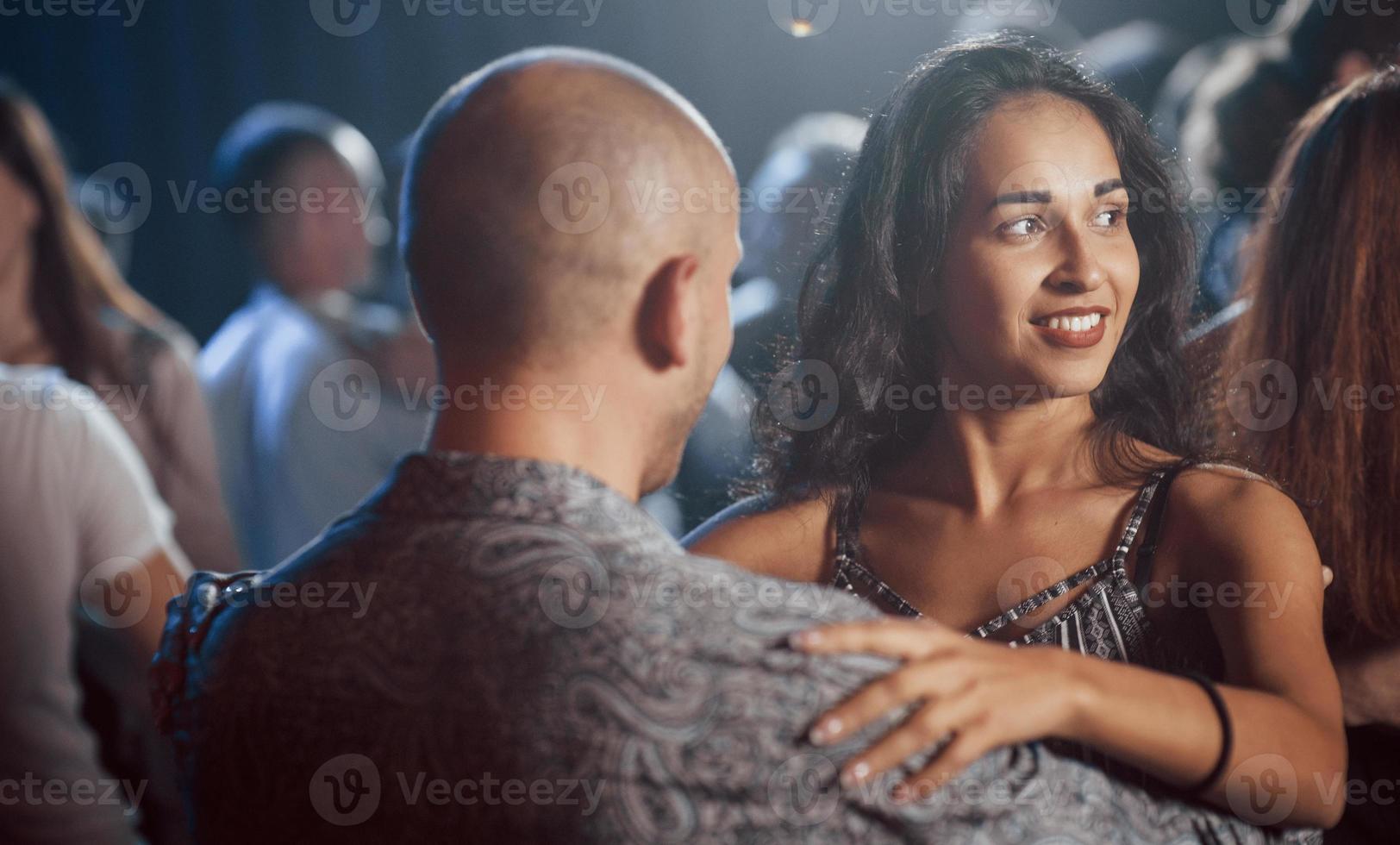 många människor runt omkring. par som dansar på natten i klubben. njuter av musik och varandra foto