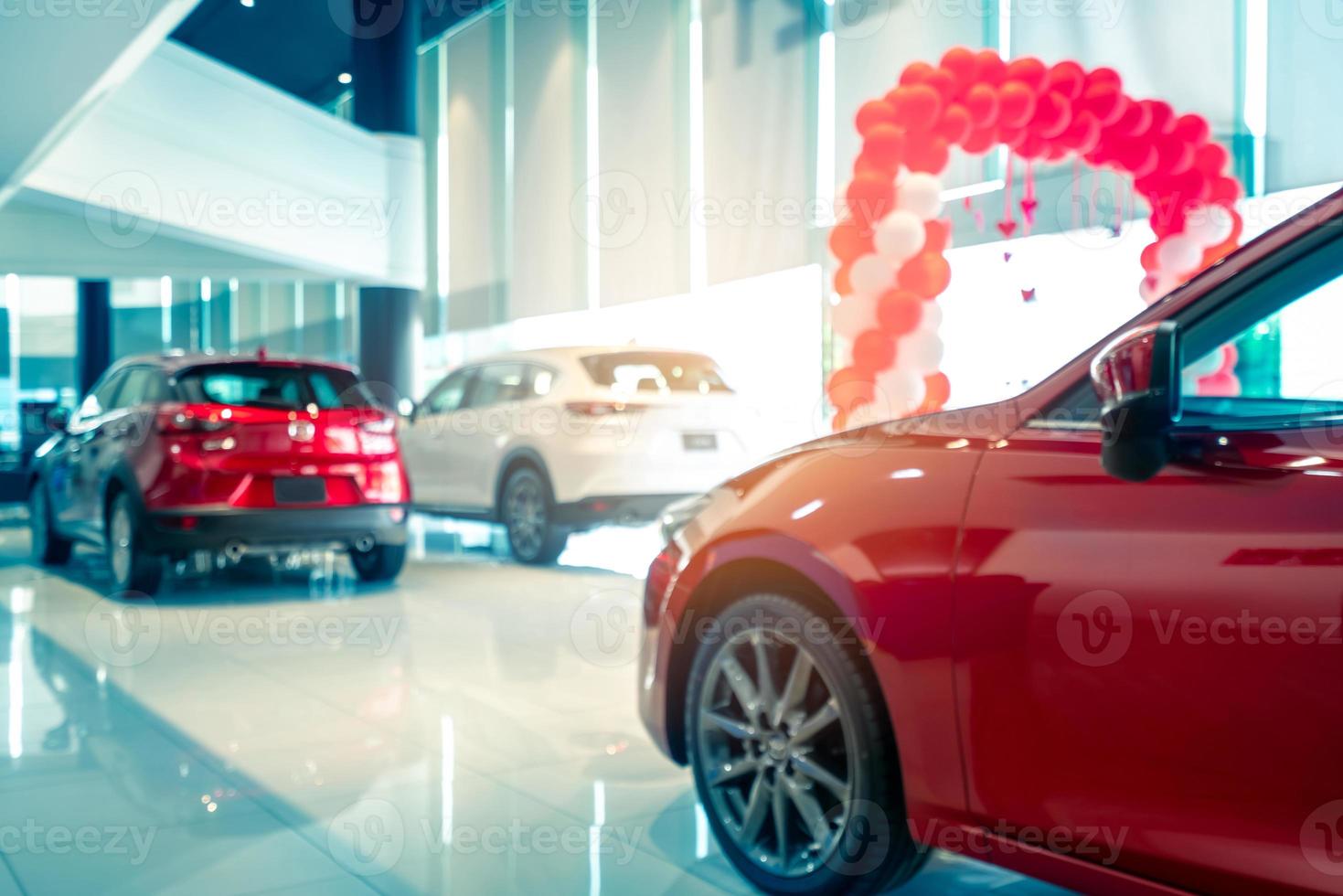 suddig bakifrån av röd och vit lyxsuvbil parkerad i modernt utställningsrum till salu. SUV-bil med sportdesign i showroom. bilåterförsäljare. Coronavirusets inverkan på bilindustrins koncept. foto