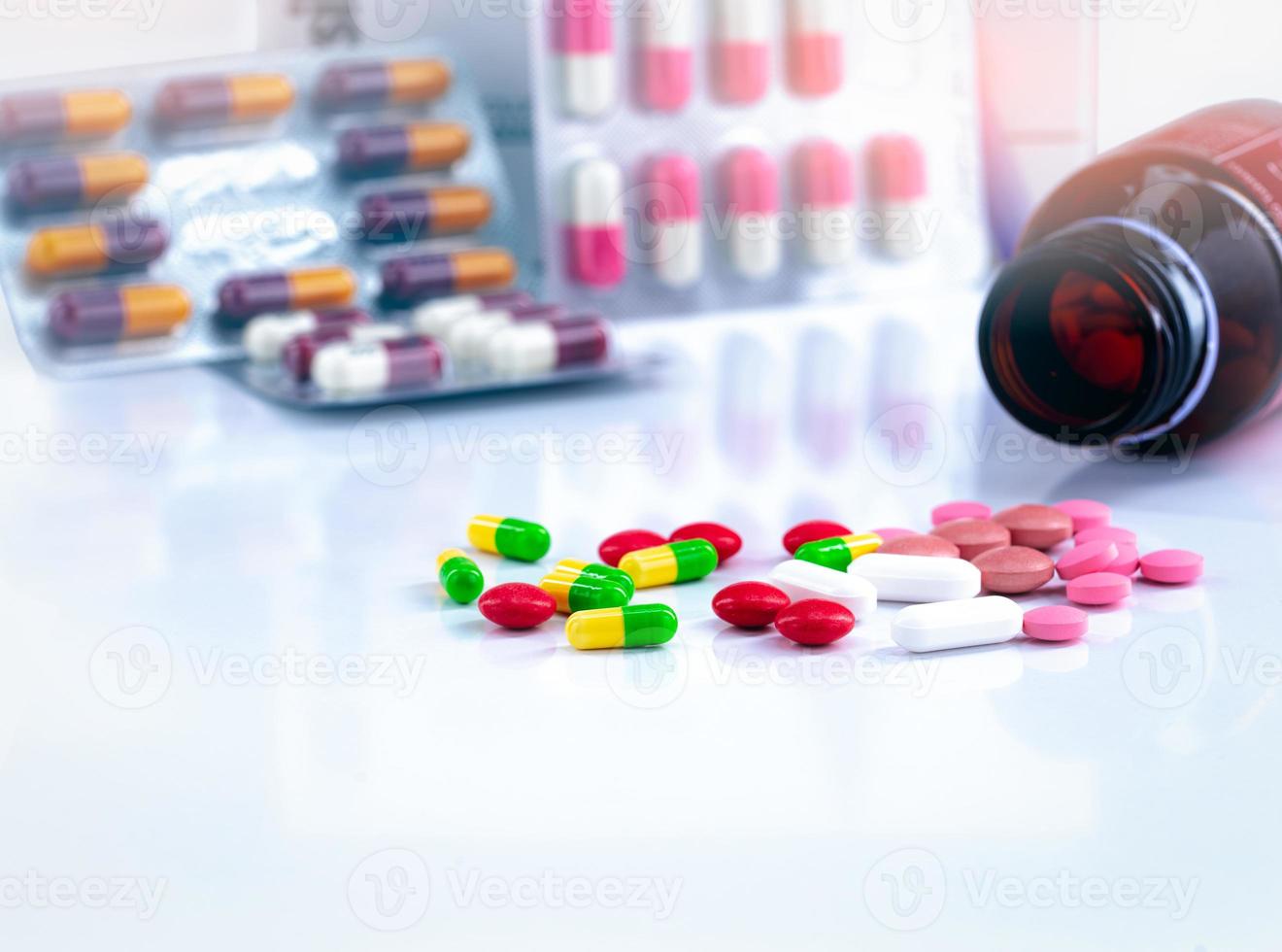 färgglada tabletter och kapselpiller på suddig bakgrund av drogflaska och antibiotikakapselpiller. läkemedelsindustri. bakgrund för innehållet i droganvändning hos gravida kvinnor och äldre. foto