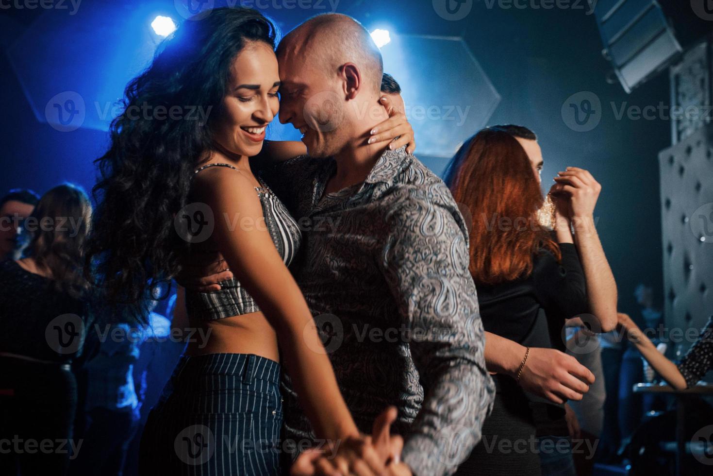 leende under processen. par som dansar på natten i klubben. njuter av musik och varandra foto