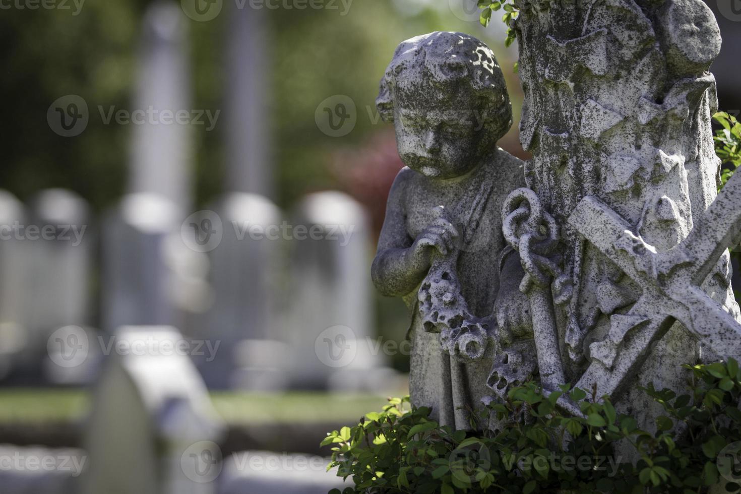 staty av ängel med kors och ankare foto