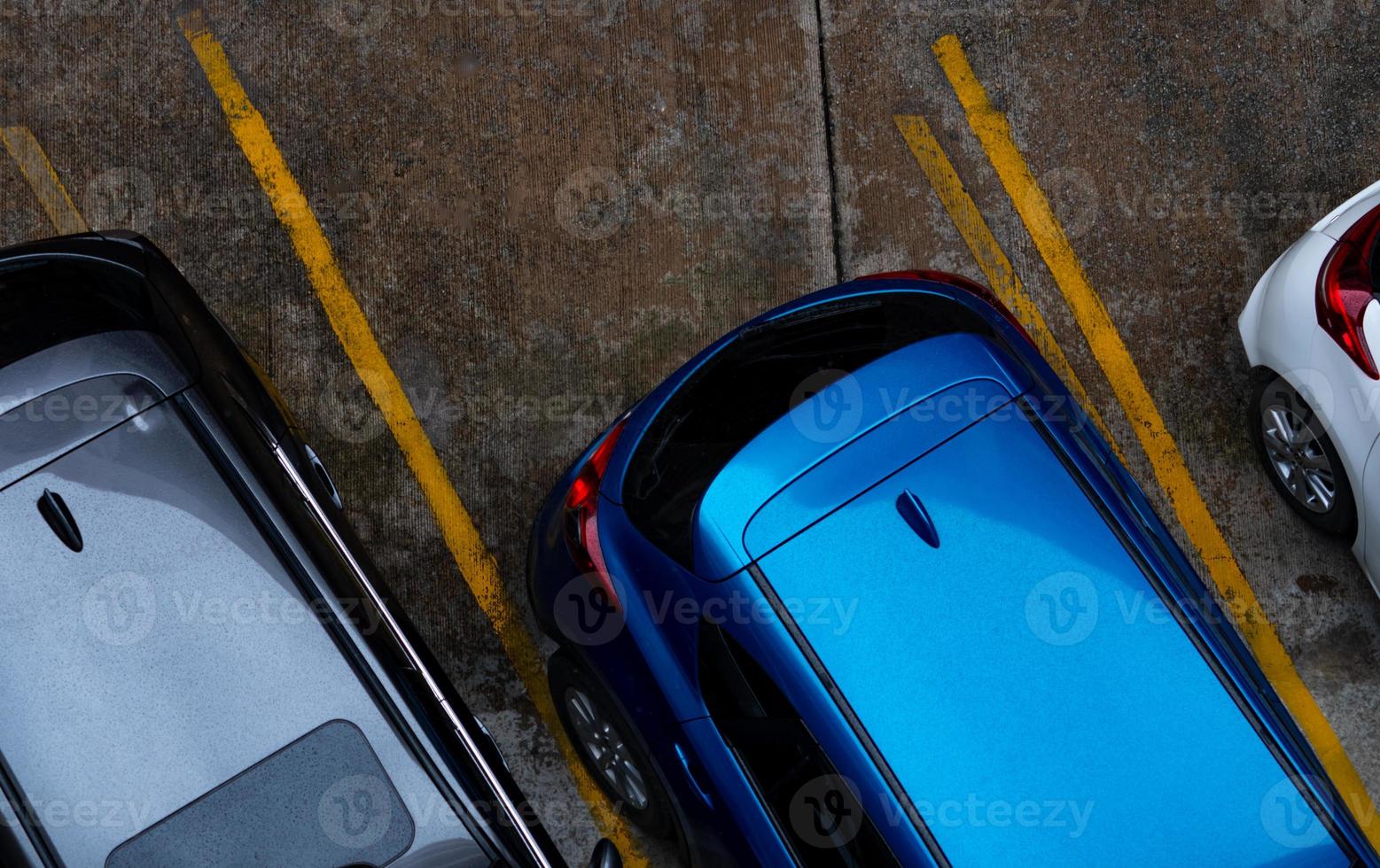 ovanifrån av bilen parkerad på betong parkeringsplats med gul linje av trafikskylt på gatan. ovan vy av bil i rad vid parkeringsplats. ingen ledig parkeringsplats. utanför parkeringsplatsen. foto