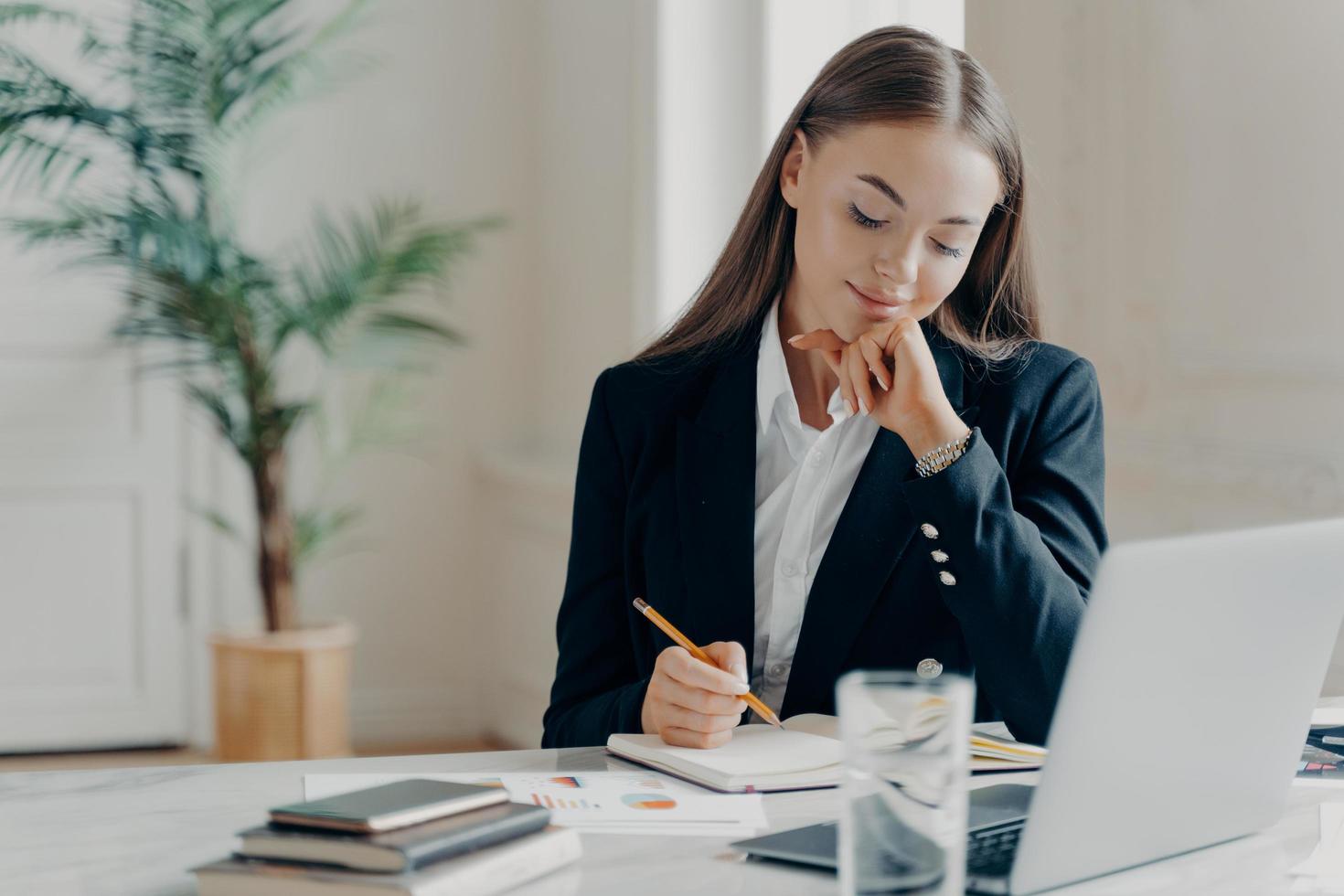 koncentrerad affärskvinna som tänker på arbetsfrågor på kontoret foto