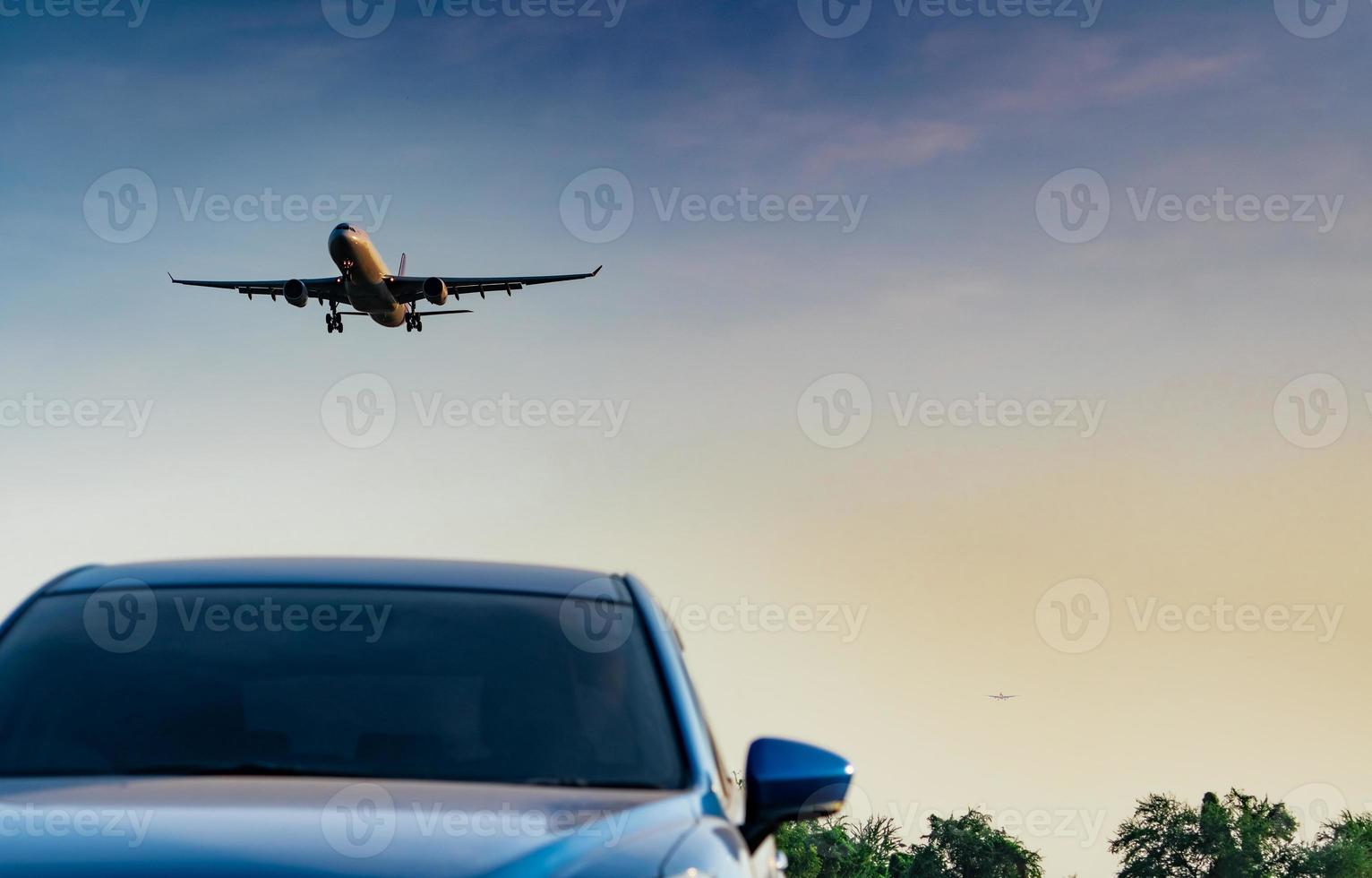 kommersiellt flygbolag. passagerarplan landar strategi blå suv bil på flygplatsen med blå himmel och moln vid solnedgången. ankommande flyg. semestertid. trevlig resa. flygplan som flyger på ljus himmel. bil parkerad. foto