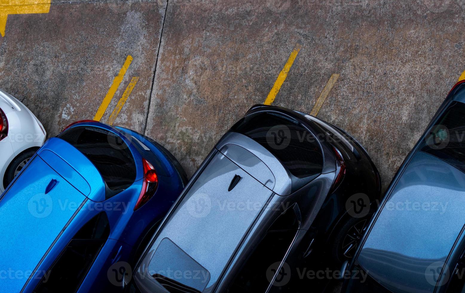 ovanifrån av bilen parkerad på betong parkeringsplats med gul linje av trafikskylt på gatan. ovan vy av bil i rad vid parkeringsplats. ingen ledig parkeringsplats. utanför parkeringsplatsen. foto