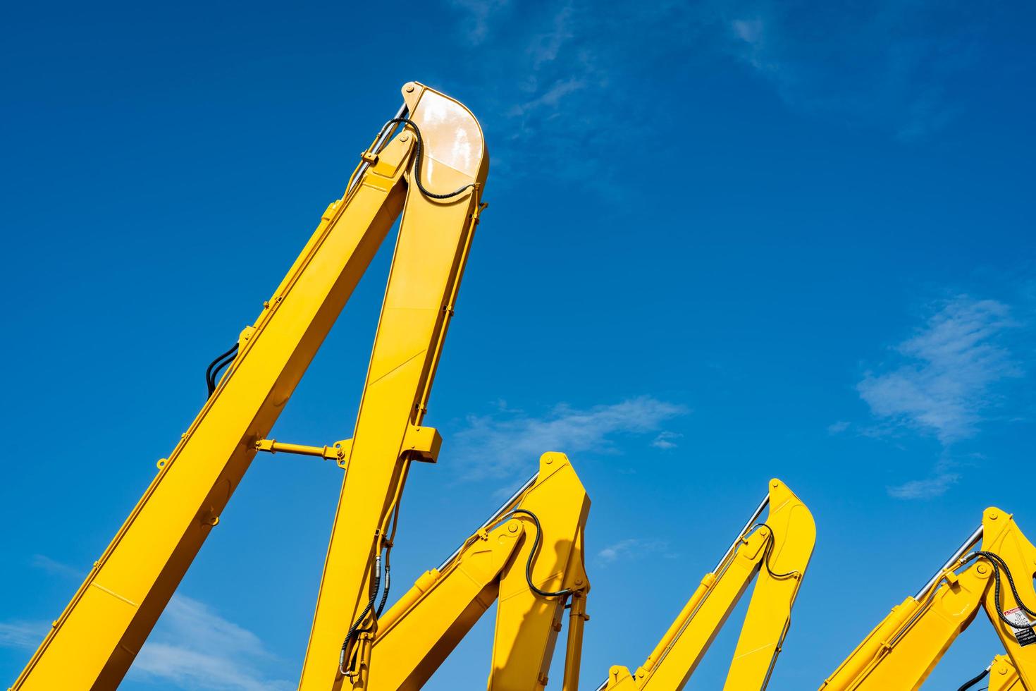 gul grävskopa med hydraulisk kolvarm mot klarblå himmel. tung maskin för schaktning på byggarbetsplats. hydrauliska maskineri. stor bulldozer. tung industri foto