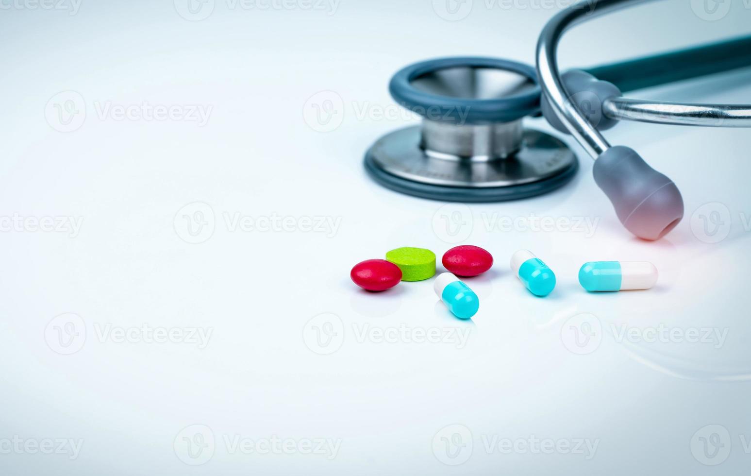 stetoskop, kapsel och tabletter piller på läkare bord eller sjuksköterska skrivbord. hälsokontroll. medicinsk sjukvård och medicinbakgrund. läkarverktyg för patientdiagnostik. kardiolog läkare utrustning. foto