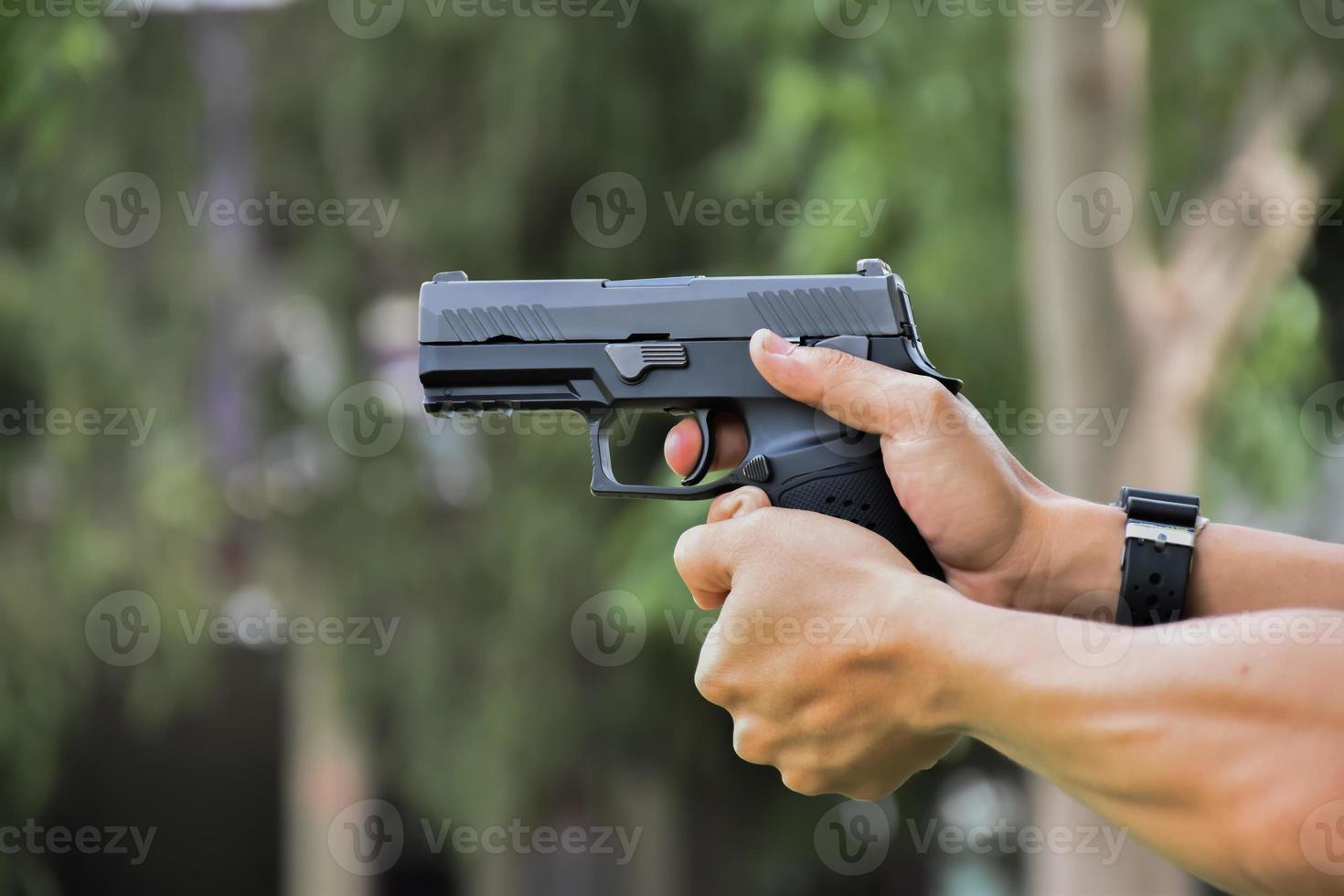 9 mm automatisk pistol som håller i höger hand på skytten, koncept för säkerhet, rån, gangster, livvakt runt om i världen. selektivt fokus på pistol. foto