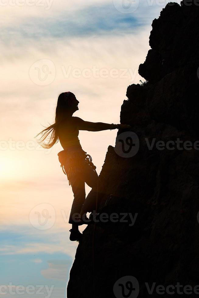 flicka ensam under en stigning i ett fantastiskt bergslandskap vid solnedgången foto