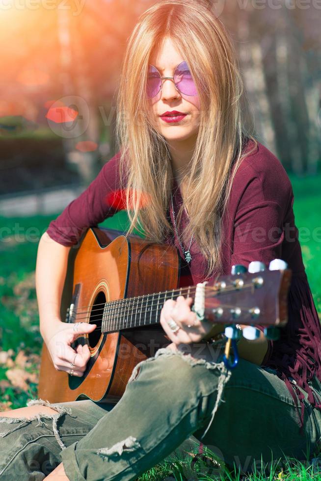 flicka med blont hår spelar gitarr foto