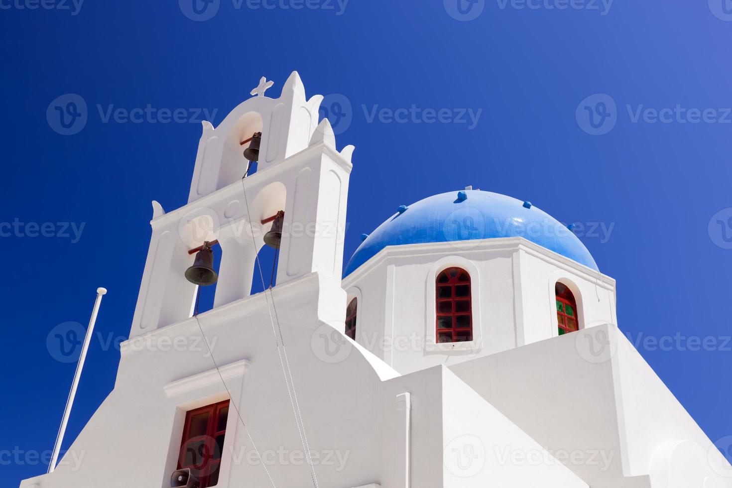 en vit kyrka med blå kupol i oia eller ia på ön santorini, grekland. foto