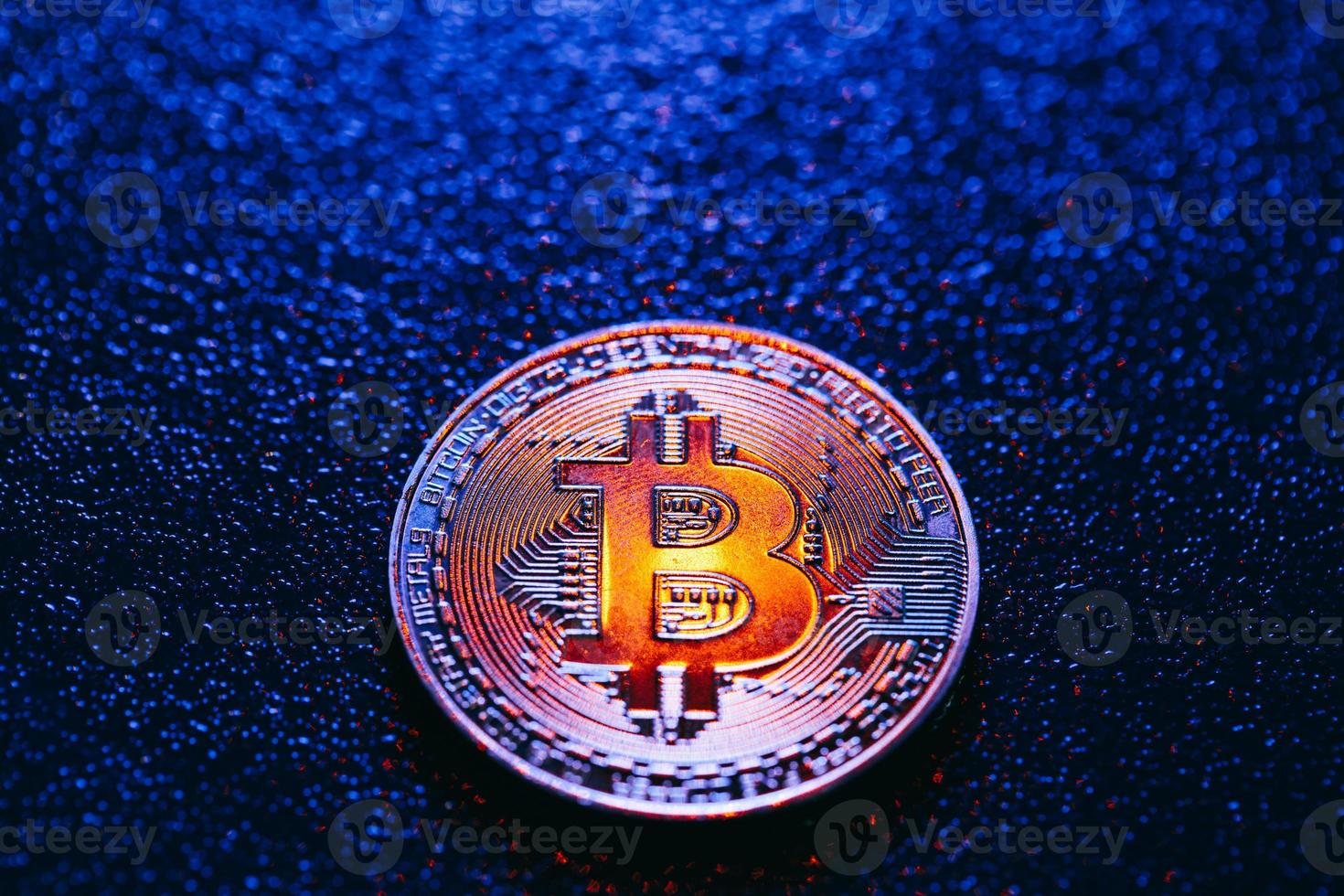 ett mynt med bitcoin-logotyp på en blå bakgrund foto
