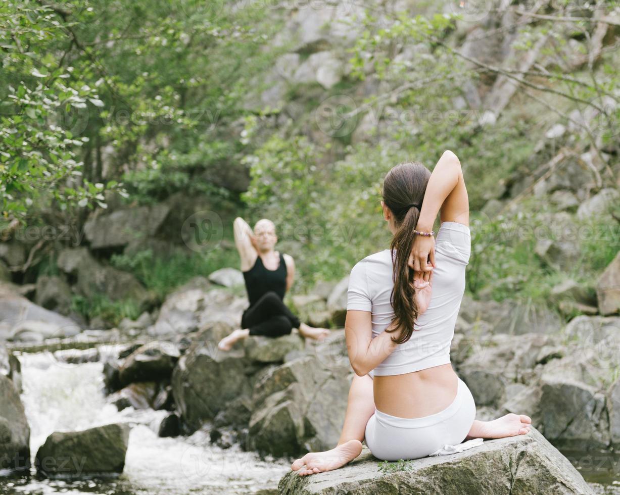 kvinna och man gör yoga i naturen foto
