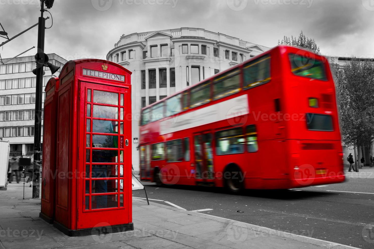 london, Storbritannien. röd telefonkiosk och röd buss i rörelse foto