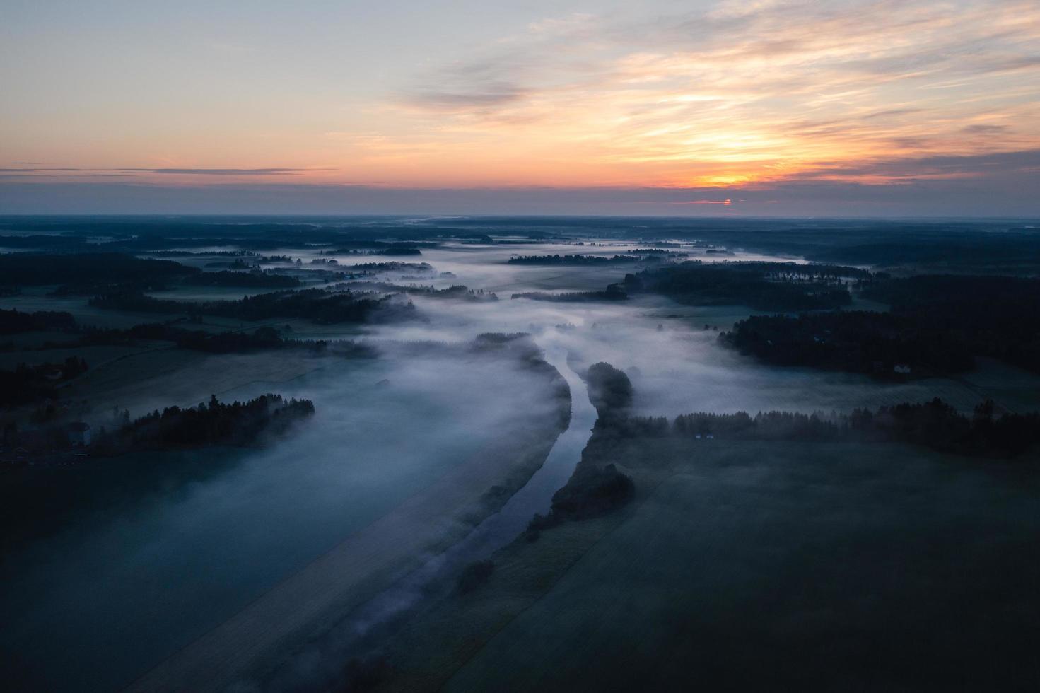 Flygfoto över en dimmig floddal i gryningen foto