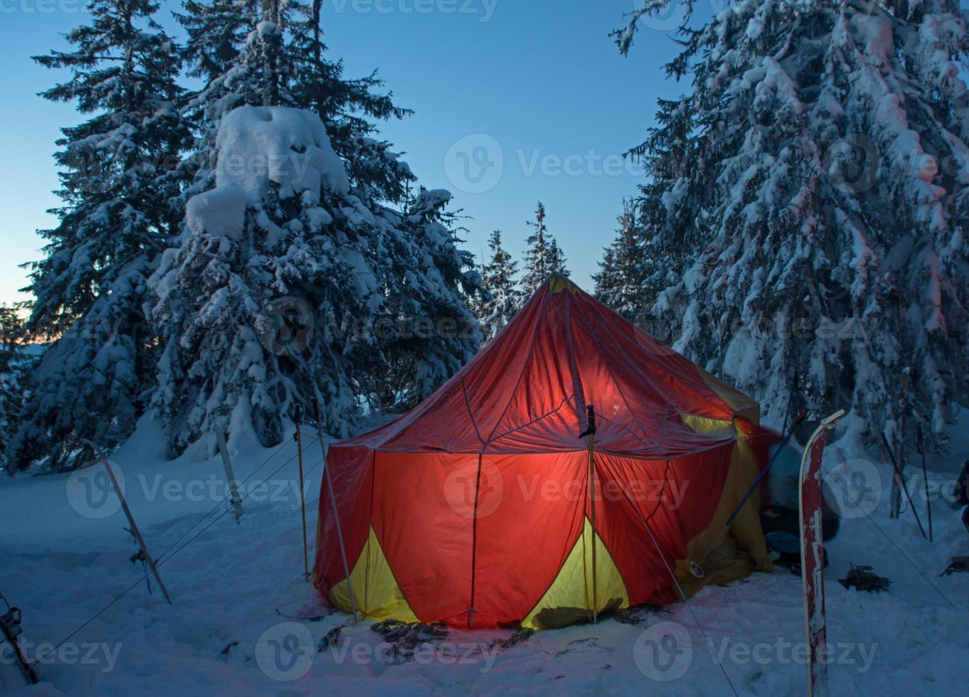 vinterskog och upplyst tält foto