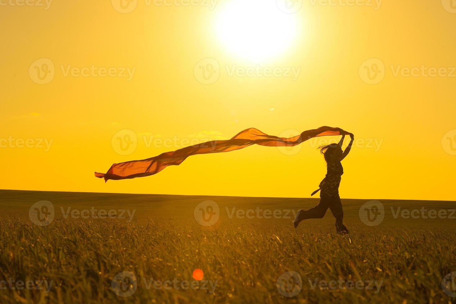 ung kvinna kör på en landsväg vid solnedgången i foto