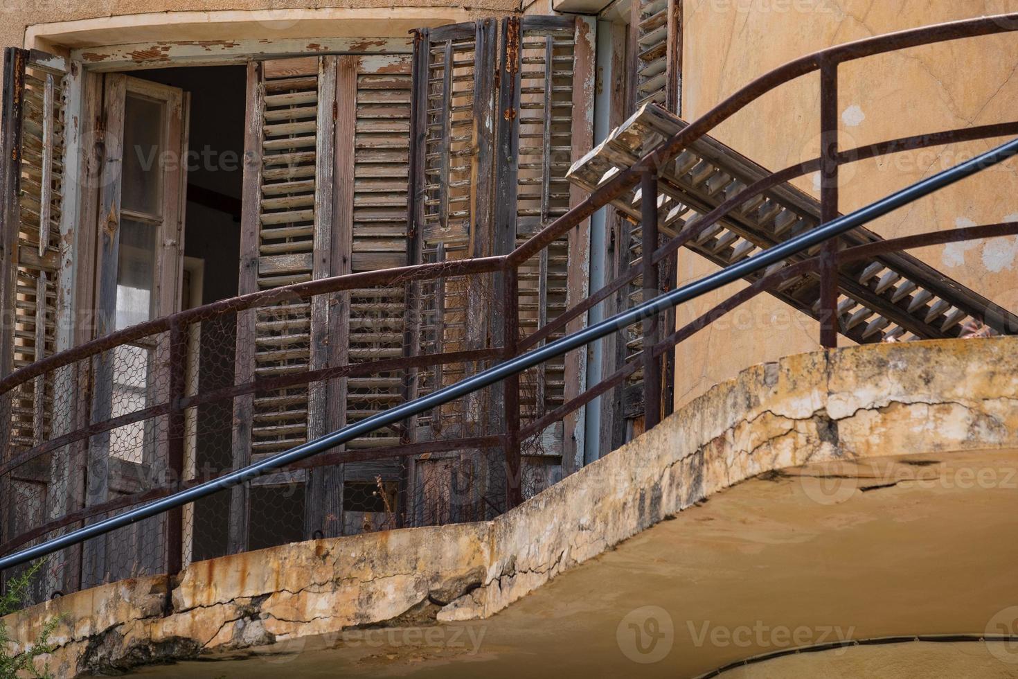 trasigt träfönster och balkong i ett övergivet hus i spökortstaden varosha famagusta, Cypern foto