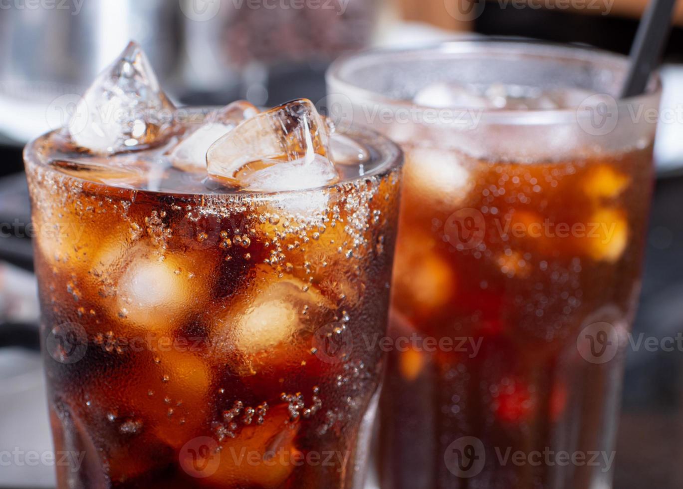 cola med krossad is i glas och det är vattendroppar runt omkring. cool svart färsk dryck. foto