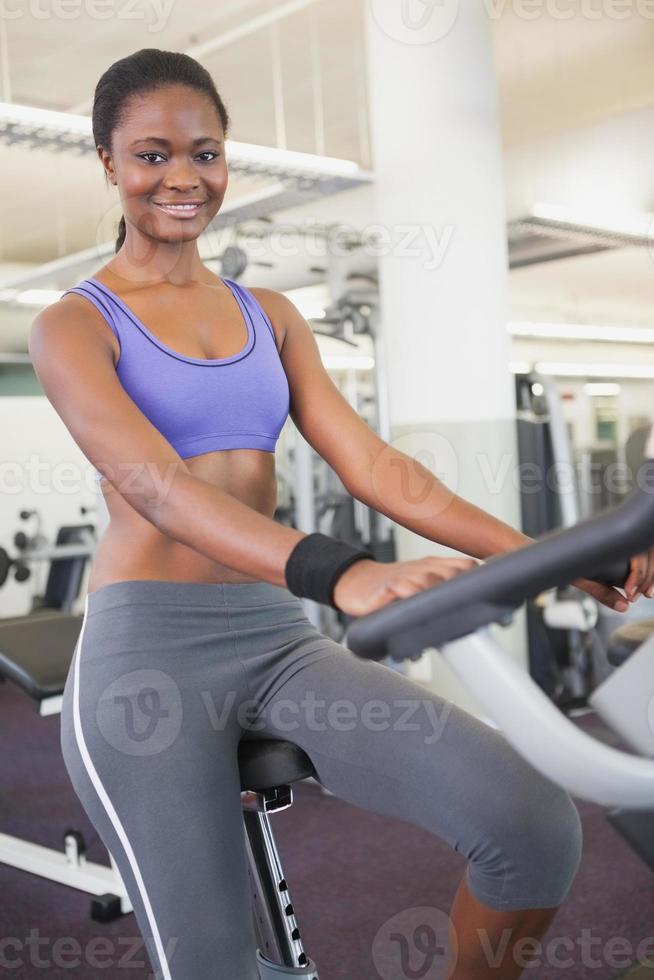 fit kvinna som tränar på motionscykeln foto