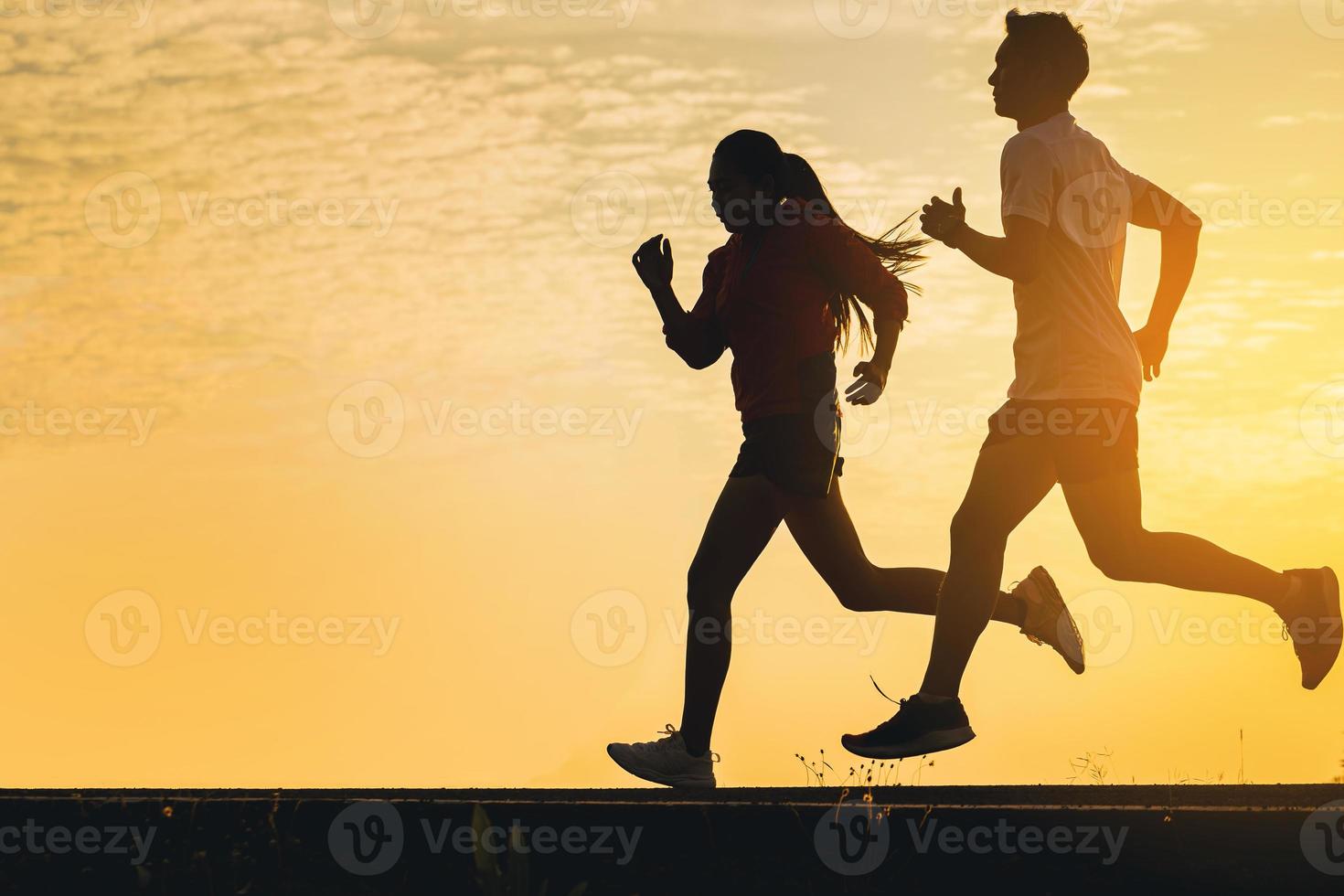 siluett av ung kvinna börjar springa på vägbanan. fit löpare fitness löpare under utomhusträning med solnedgång bakgrund. valt fokus foto