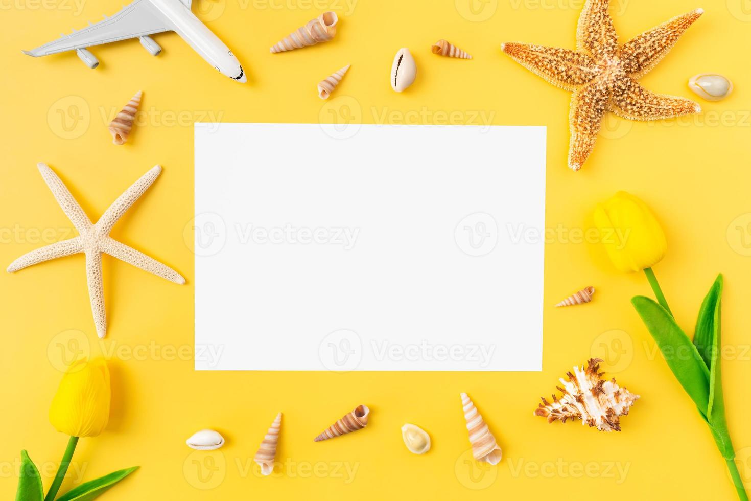 ovanifrån av blankt papper för reklamskyltar med sjöstjärnor och strandtillbehör på gul bakgrund. sommartid koncept. foto