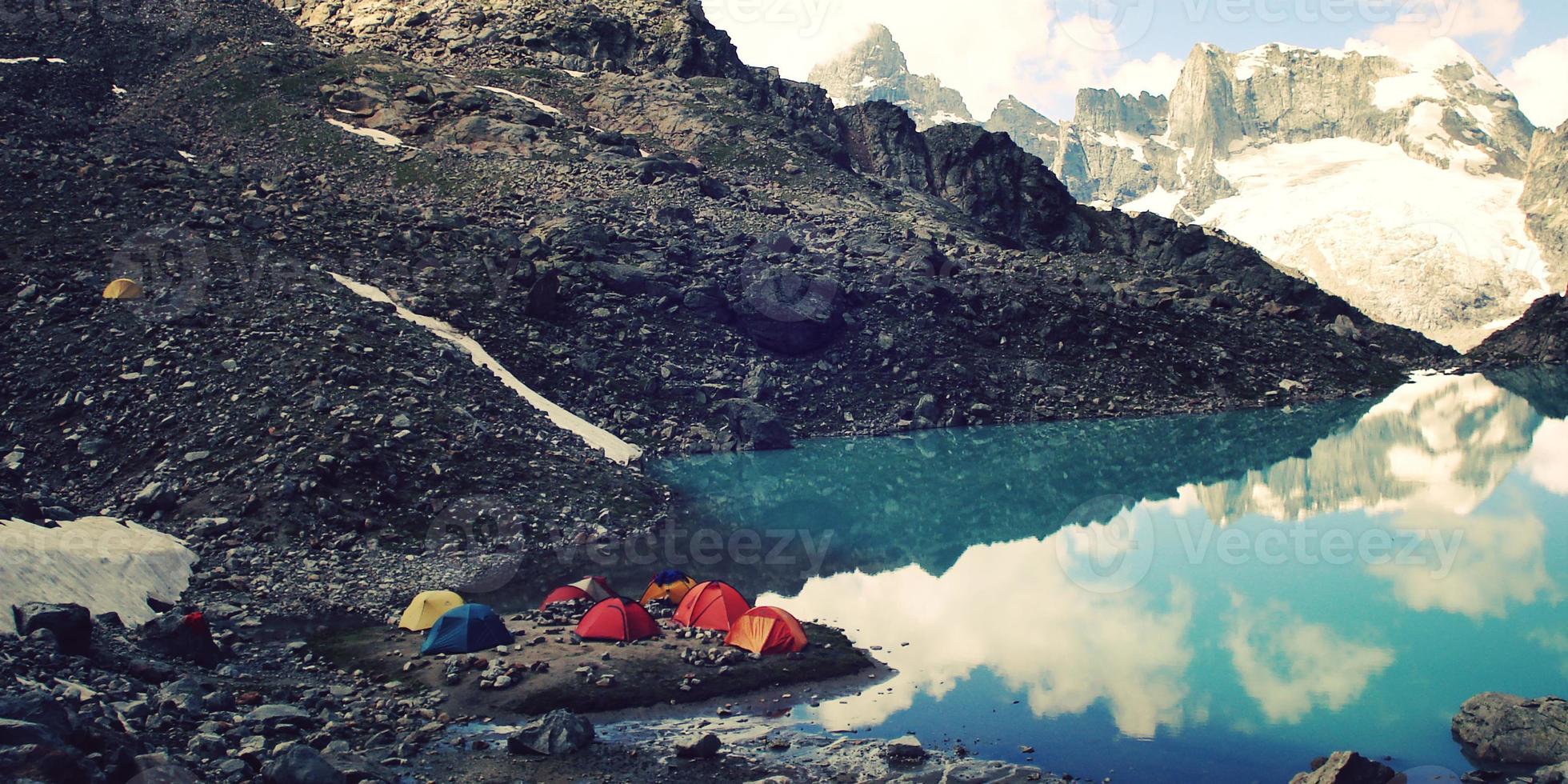 camping nära alpin sjö vintage effekt. färgglada tält. Kaukasusbergen. foto