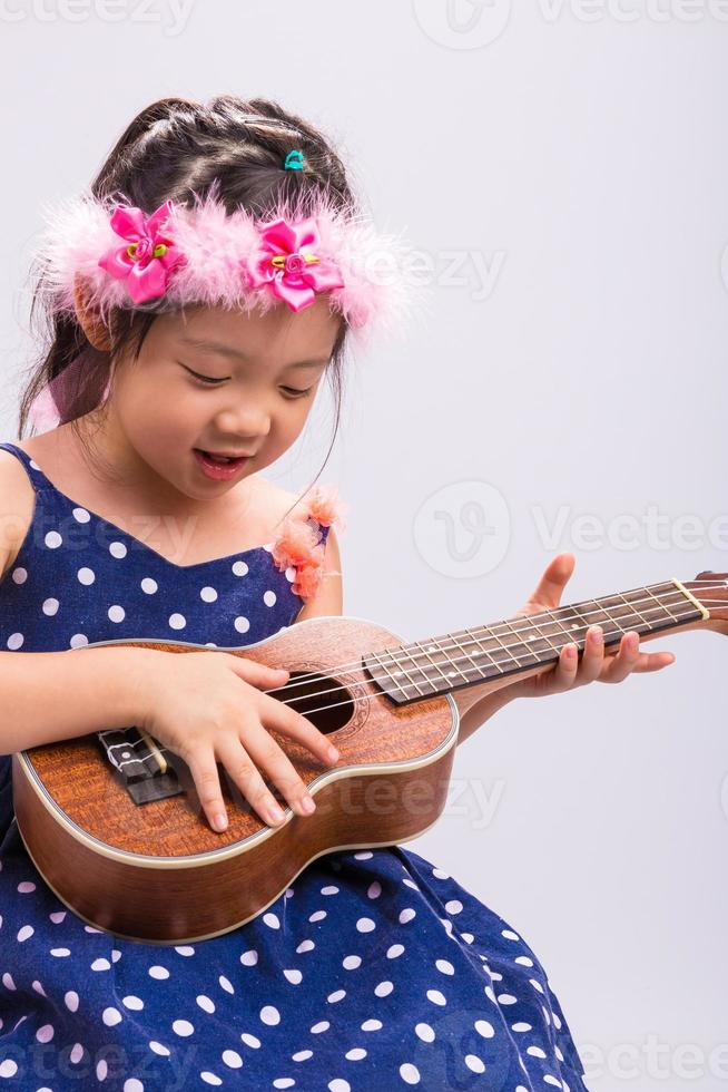 barn som spelar ukulele / barn som spelar ukulele bakgrund foto