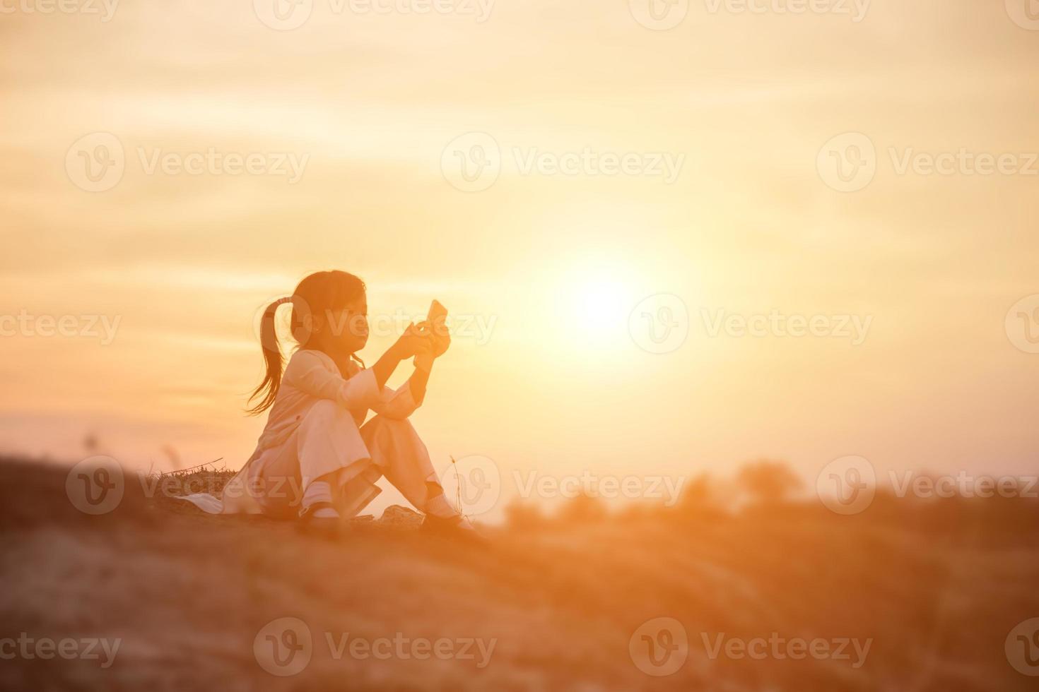 flicka på stranden textar på solnedgången foto