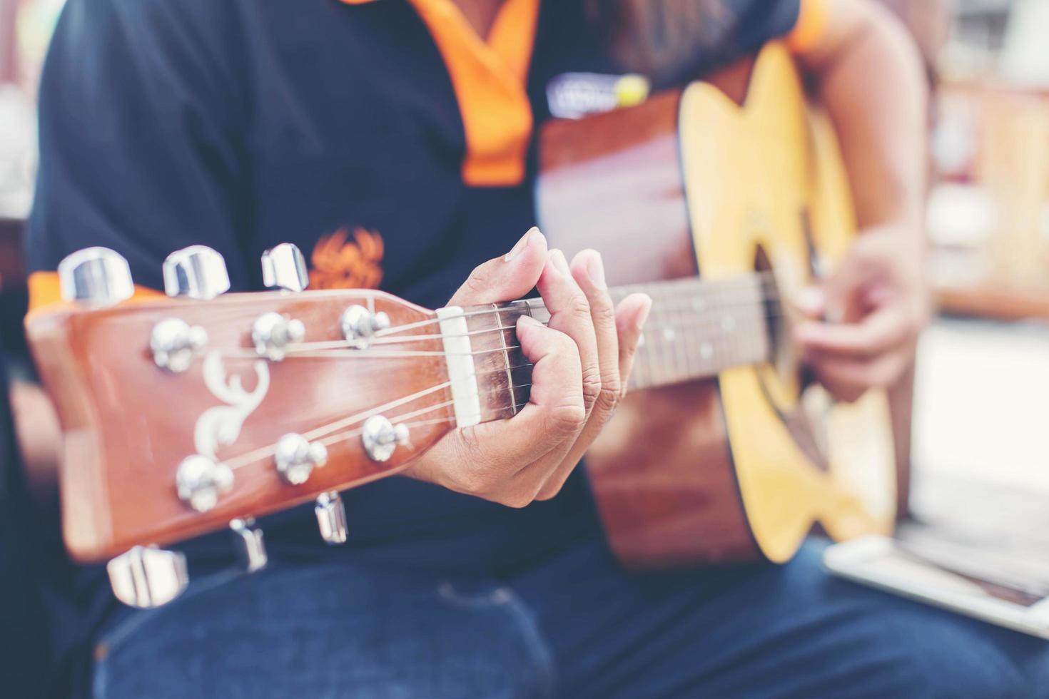 närbild av manhand som spelar gitarr foto