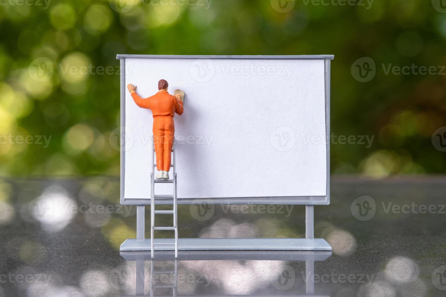 miniatyr människor målare arbete på framsidan av en whiteboard foto