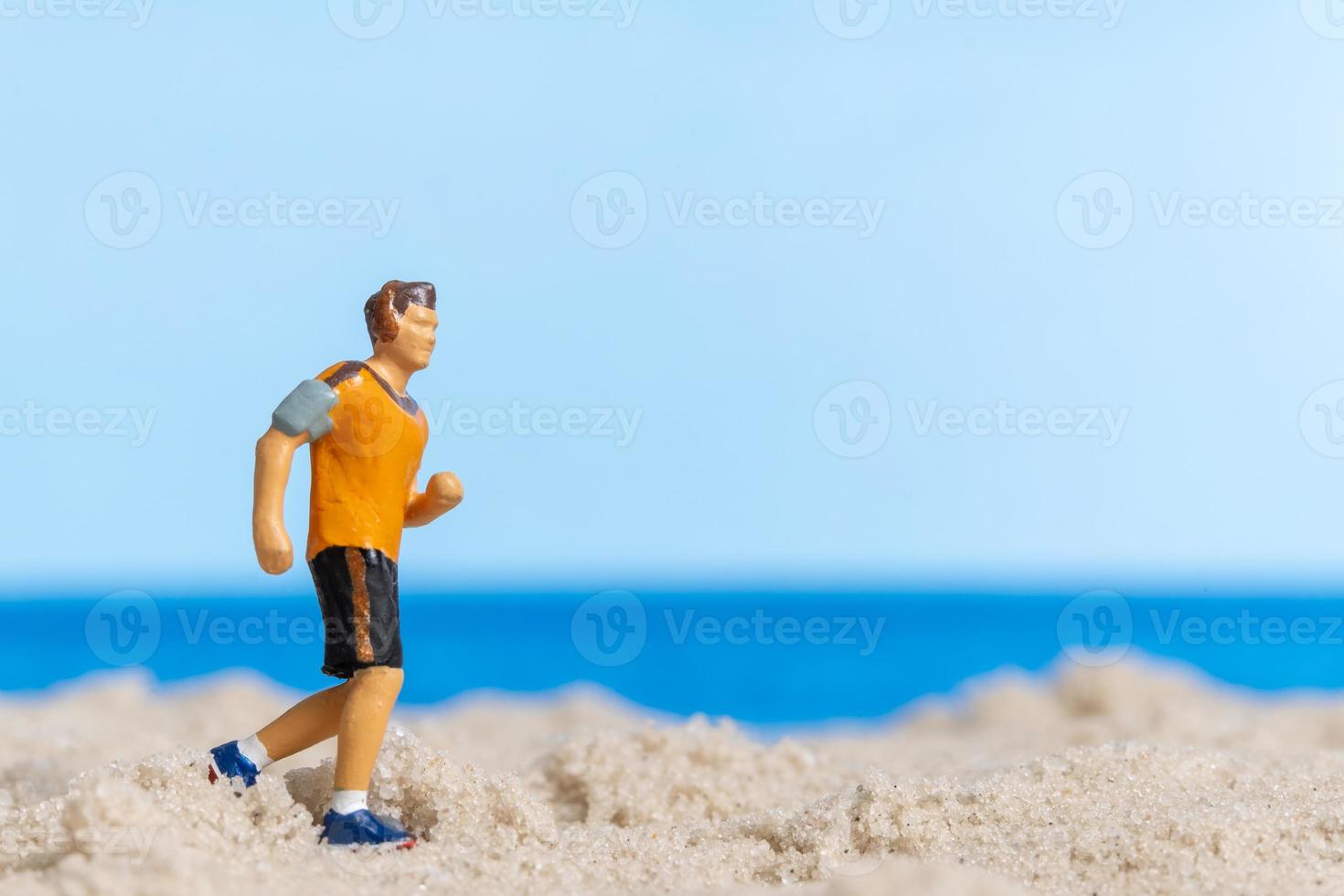 miniatyr människor springer på stranden foto
