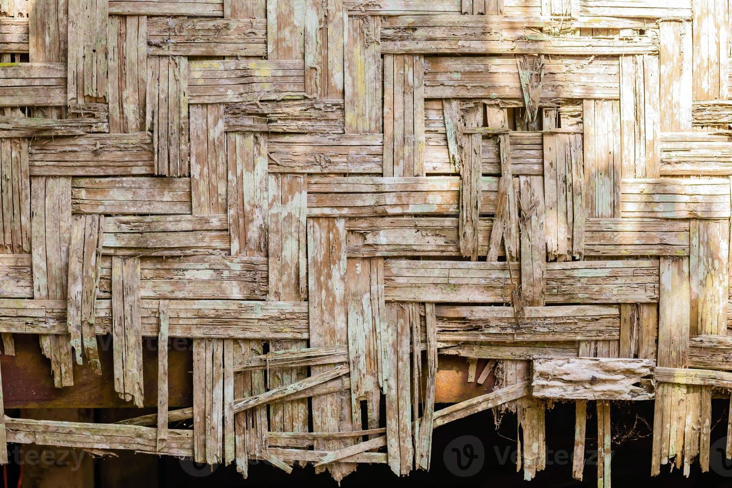 gammal husvägg gjord av bitar av bambu, bakgrund. foto