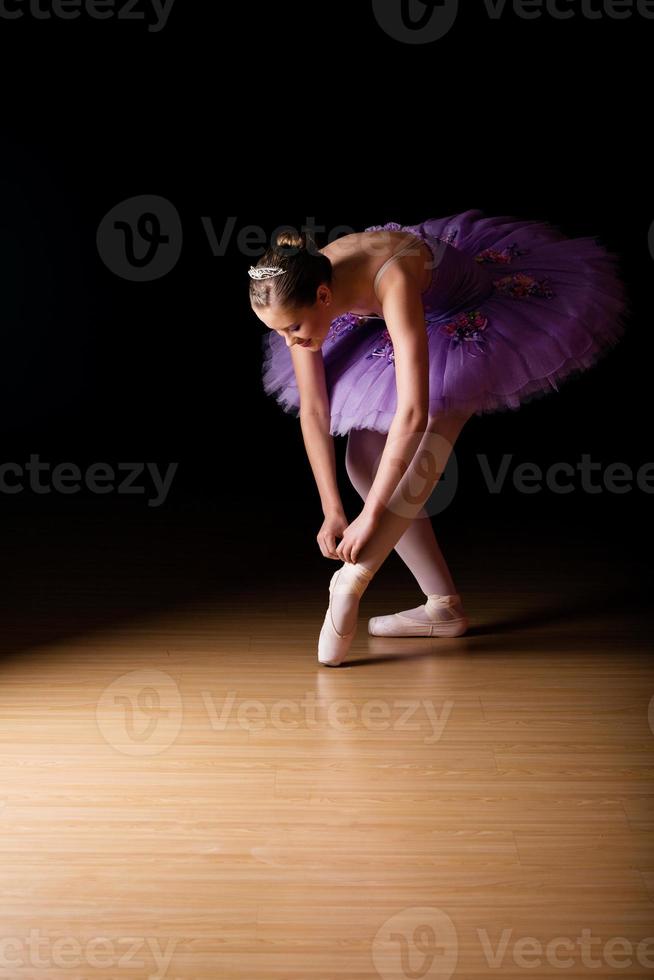 ung kvinnlig ballerina som justerar sina skor foto
