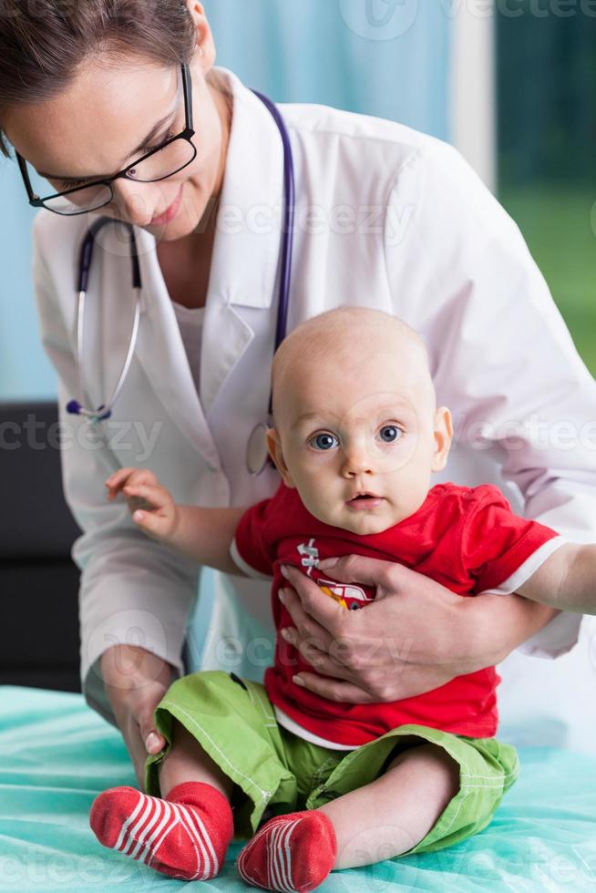 kvinnlig barnläkare med liten pojke foto