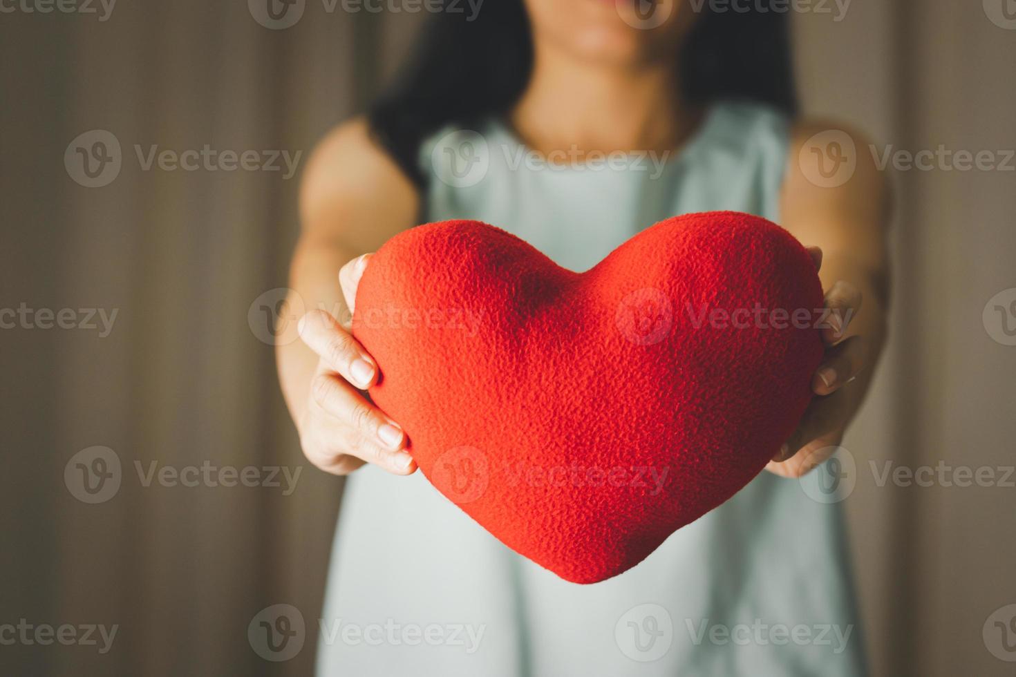 närbild av kvinna som håller en hjärtkuddemodell för alla hjärtans dag, mors dag och månad för medvetenhet om bröstcancer för sjukvården på internationella kvinnodagen foto