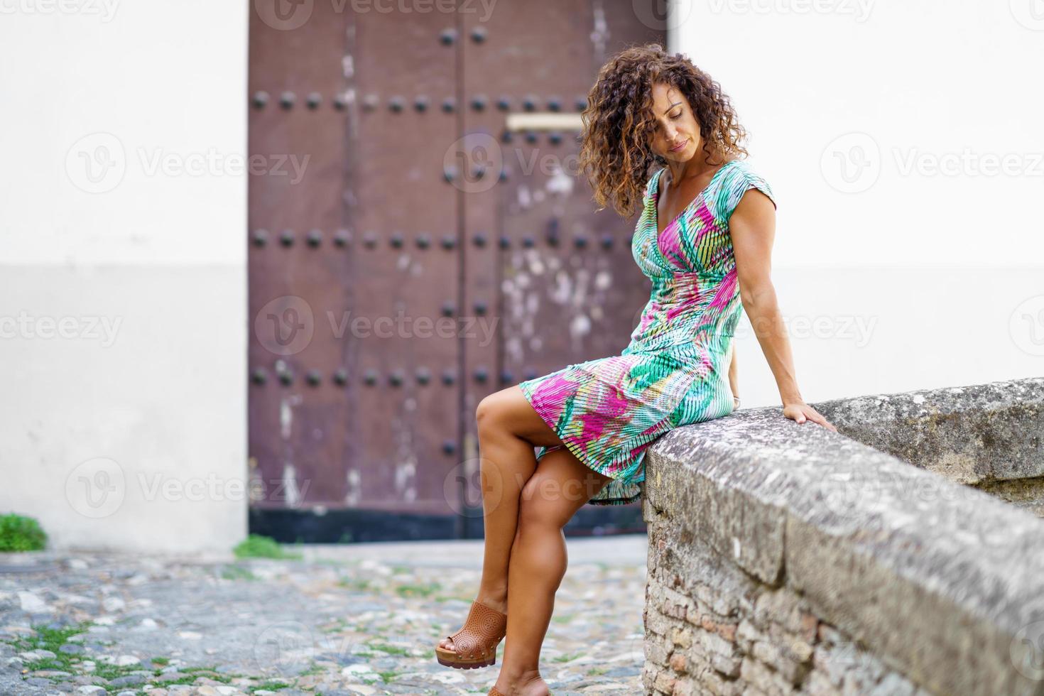 vacker brunett medelålders kvinna bär vår färgglada klänning utomhus foto