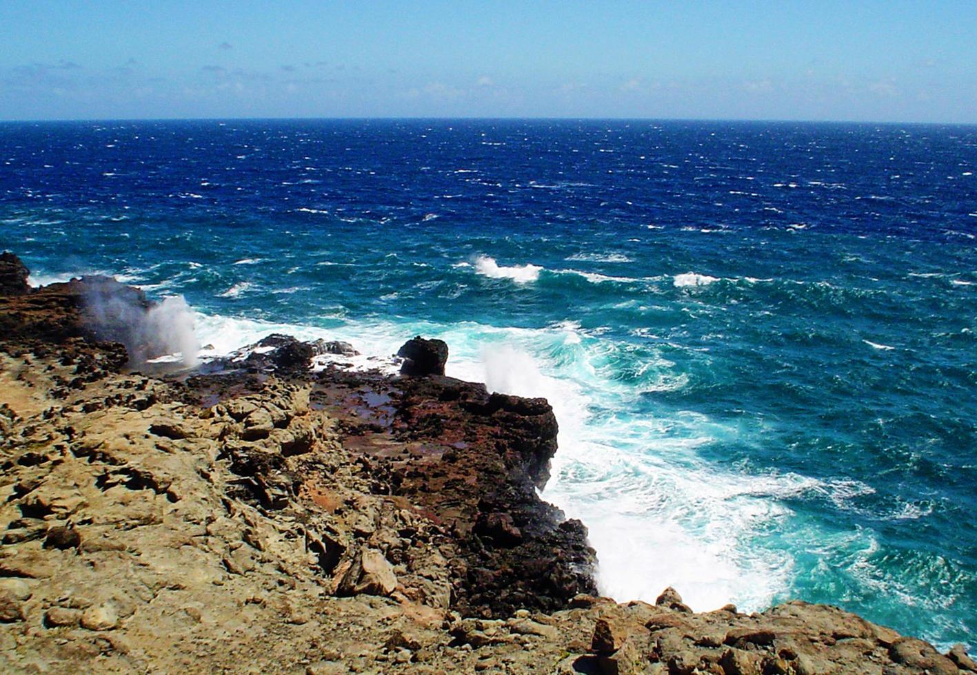 havsvatten som kommer genom ett blåshål i maui hawaii foto