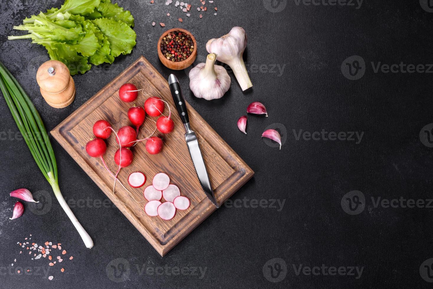 läcker färsk röd rädisa som ingrediens för att göra vårsallad på träskärbräda foto