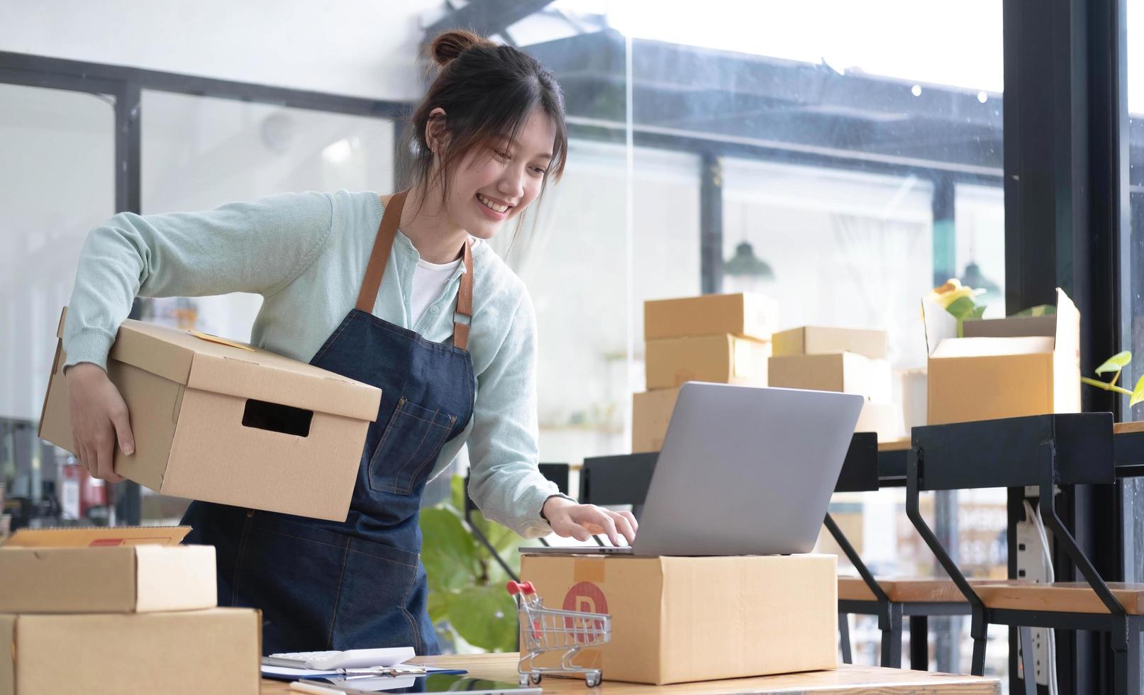 startar småföretag SME-ägare kvinnliga entreprenörer kollar onlinebeställningar för att förbereda sig på att packa lådorna, sälja till kunder, SM-affärsidéer online. foto